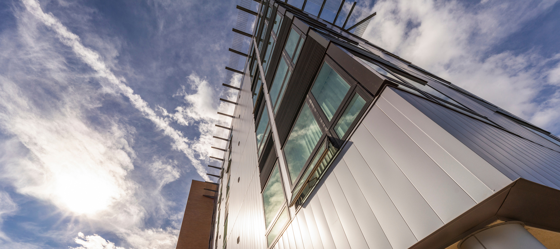 A ground up view of multifamily buildings with bright sky