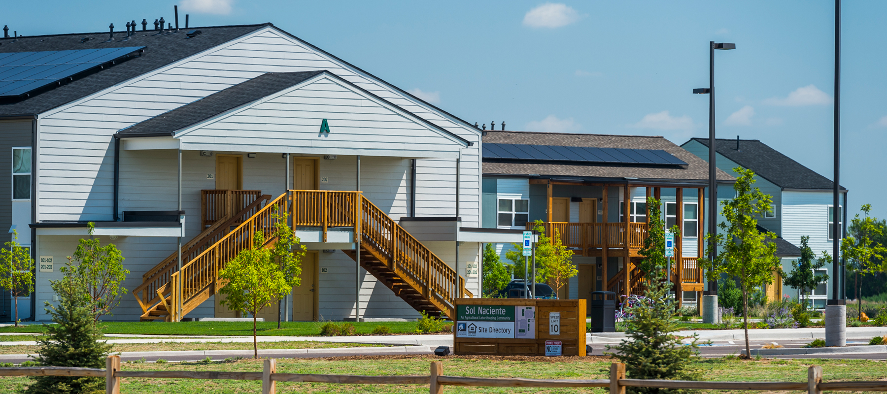 A white multifamily building with wood stairways