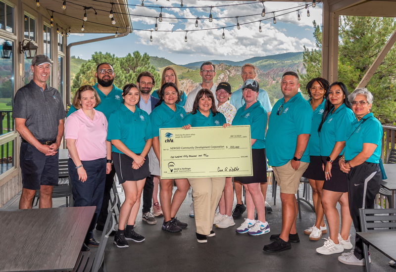 NEWSED staff and CHFA Executives standing together holding a large check