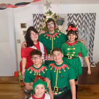 A family dressed like elves in front of a Christmas tree