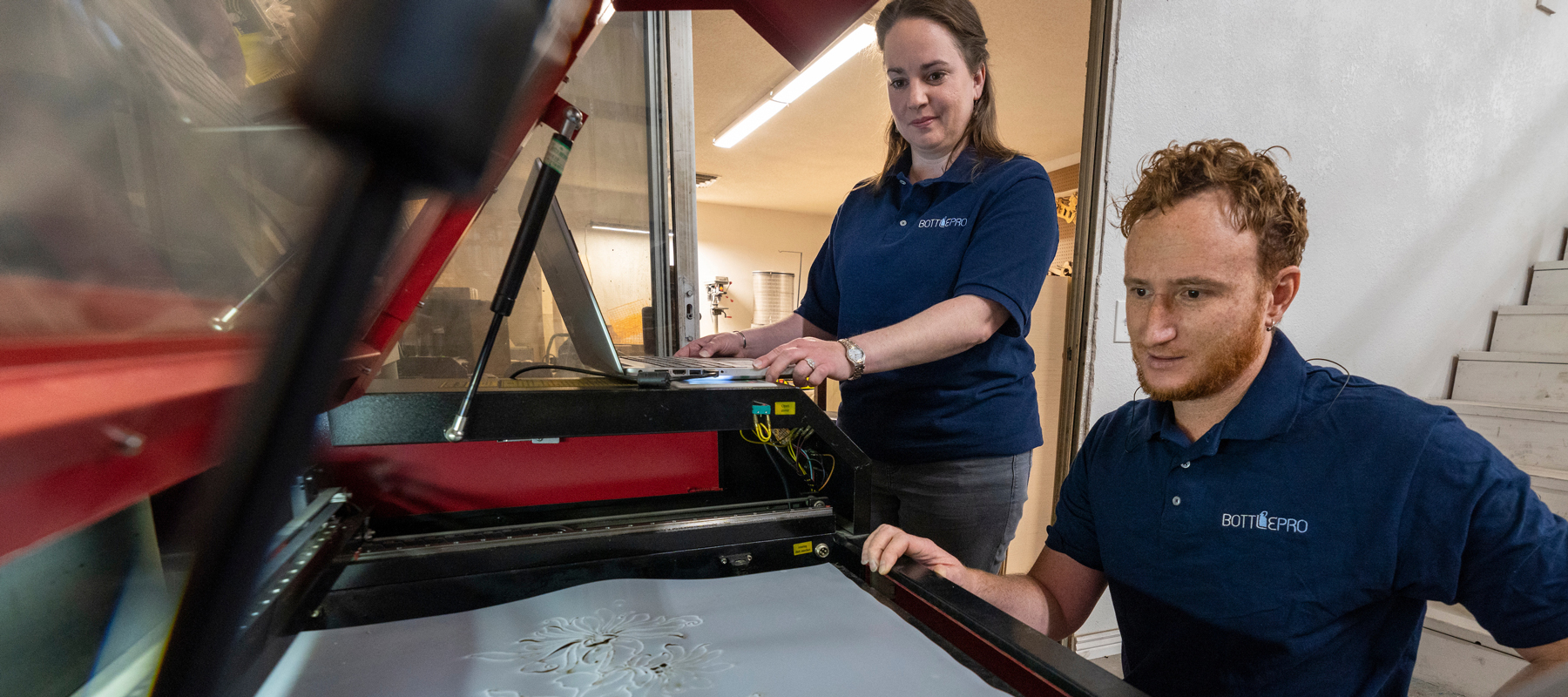 Two people looking into a machine