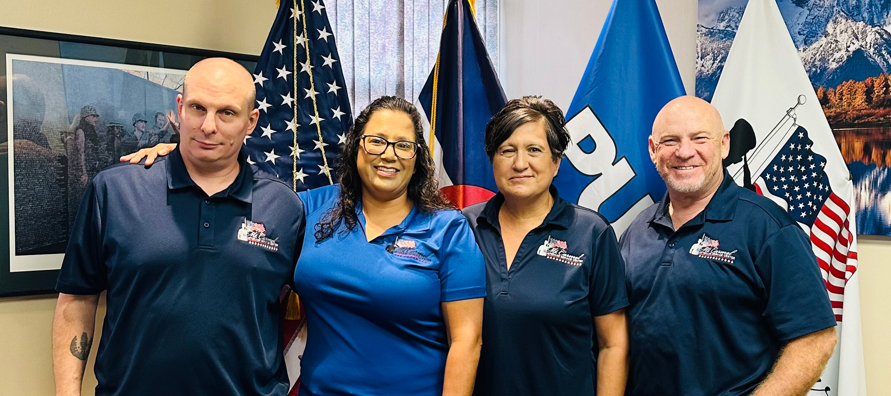 Four people from Mt. Carmel Veterans Service Center standing in front of four flags