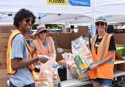 Three people in orange vests smiling at the camera