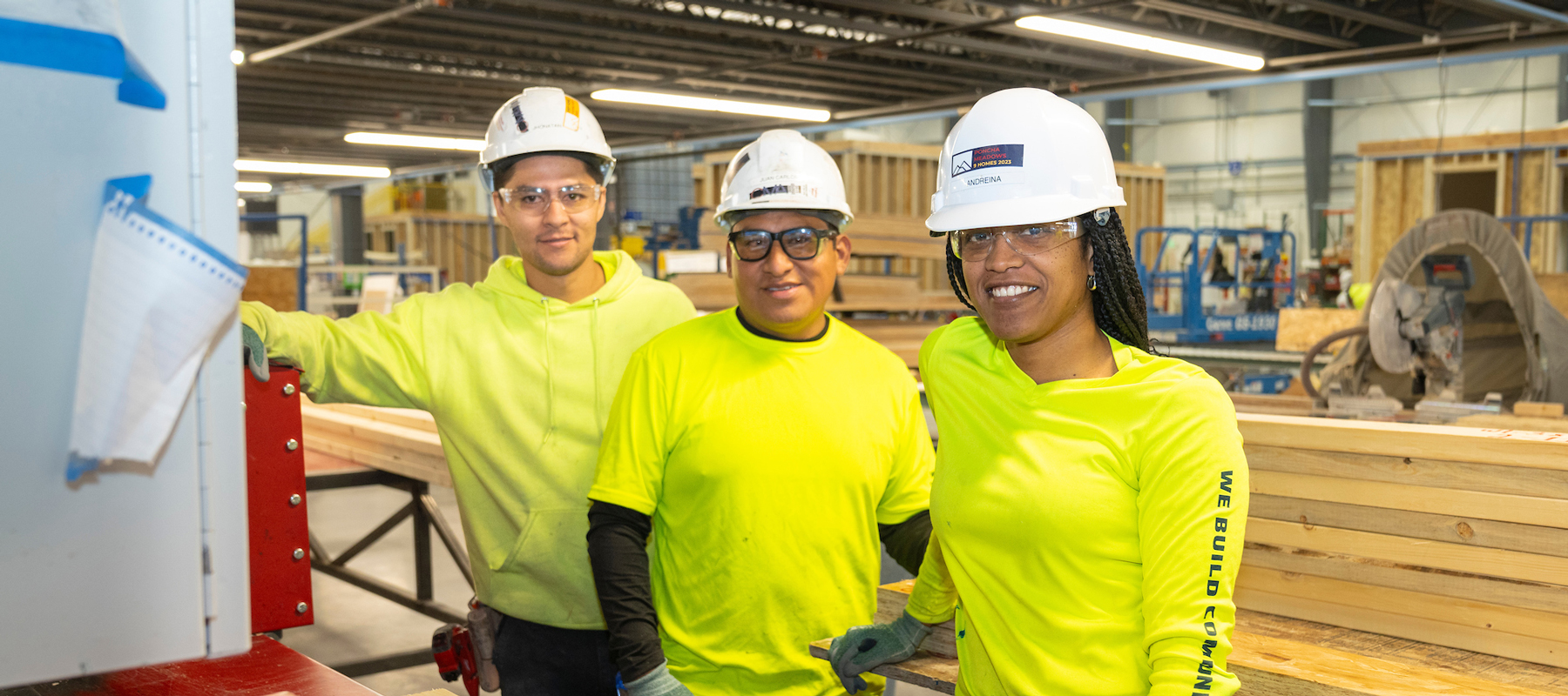 Three people in bright yellow tshirts and hard hats